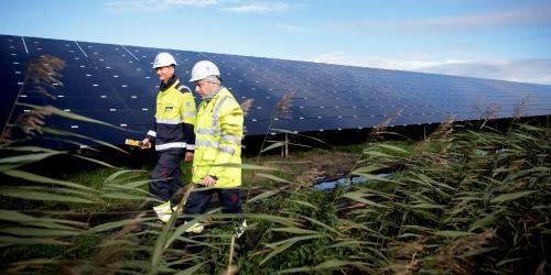 Two employees walking around at Lange Runde solar park. (Photo: Ole Martin Wold)